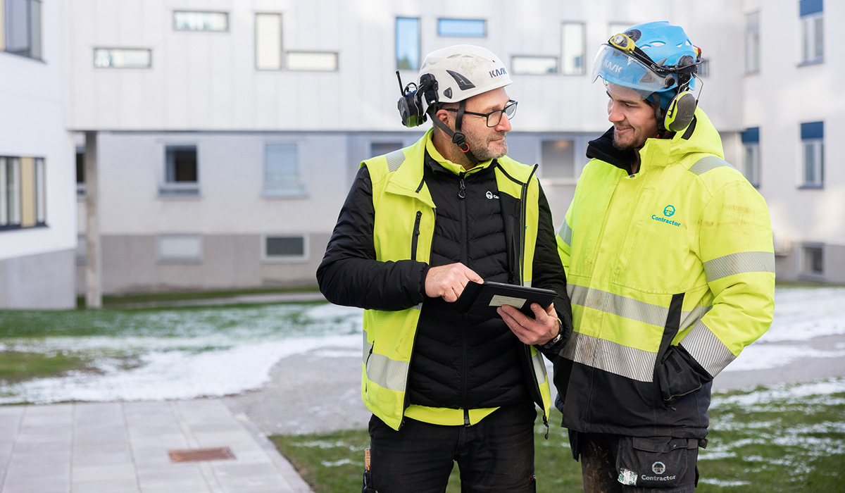 två arbetare från Contractor som står och diskuterar jobbet över Lycksele lasarett.