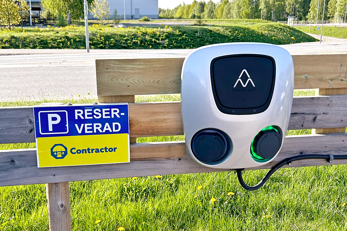 Elbilladdare som blivit uppsatt på ett staket, med en skylt där det står reserverad Contractor.