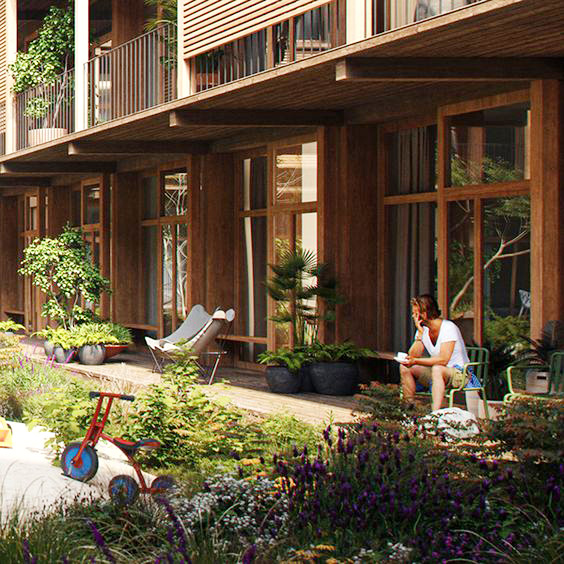 man sitter på altanen med en kopp i handen. trähus med stora glaspartier.