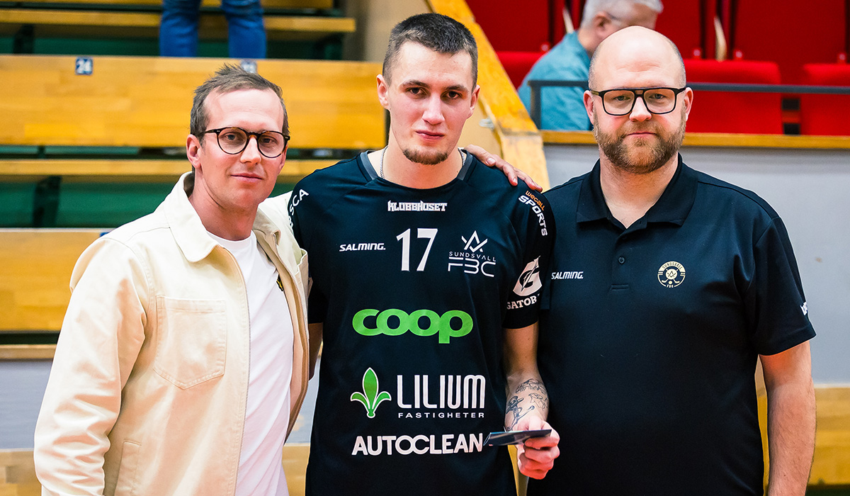 3 män som står och håller armarna om en innebandyspelare.